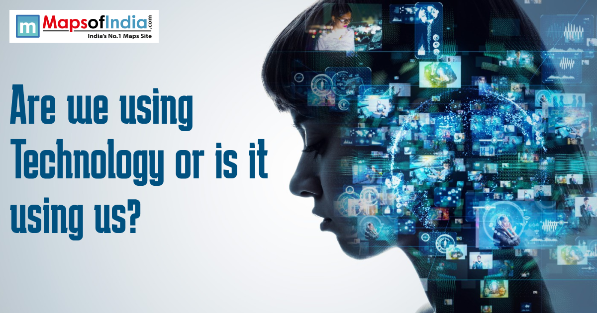 Side profile of a person’s face filled with digital screens, data visuals, and technology icons, alongside the text ‘Are we using technology or is it using us?’ and a MapsofIndia logo at the top.